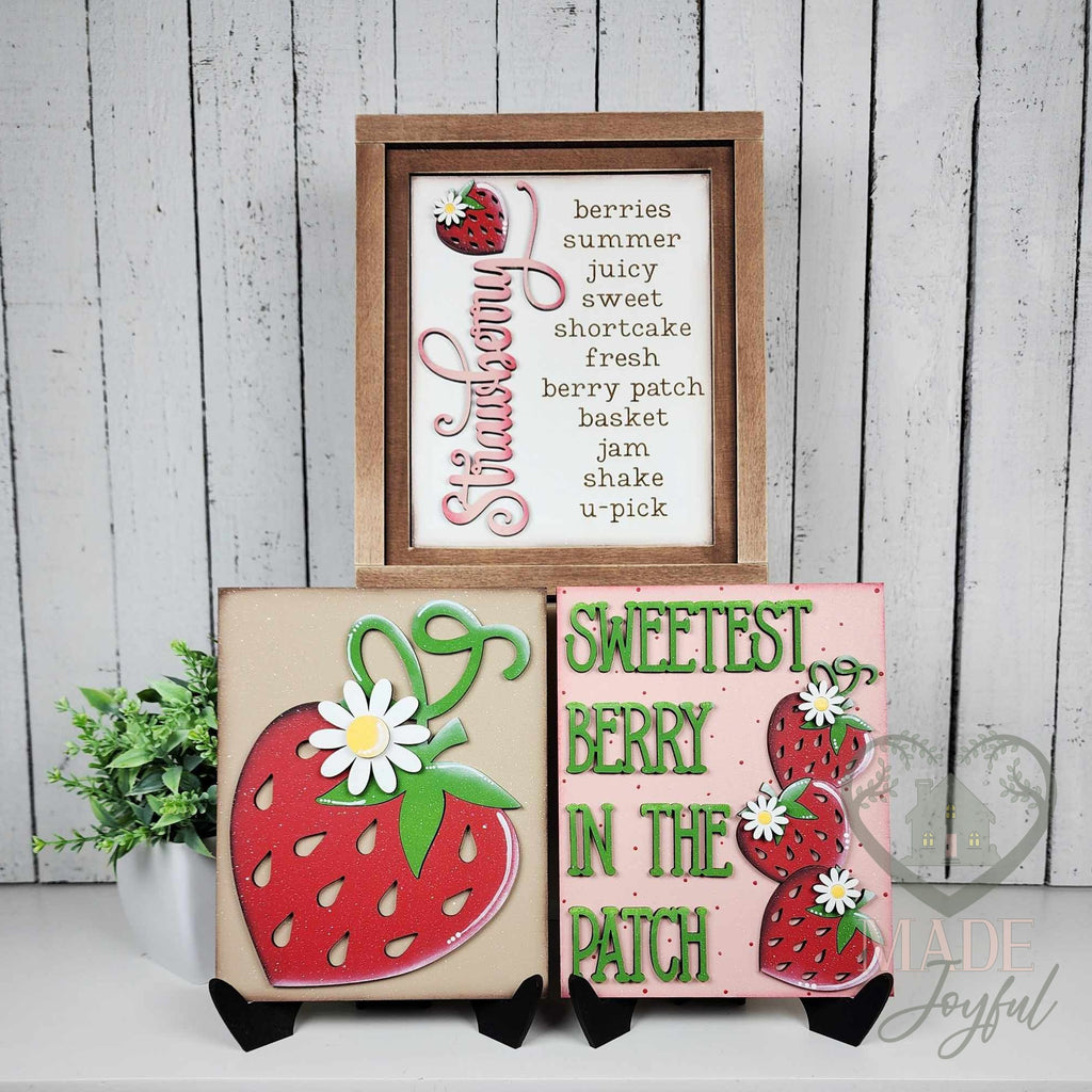 Berry Sweet strawberry insert trio for interchangeable farmhouse frames: the Strawberry word sign in a stained wood frame with the big strawberry and Sweetest Berry in the Patch inserts on stands, hand-painted in Brentwood, TN.