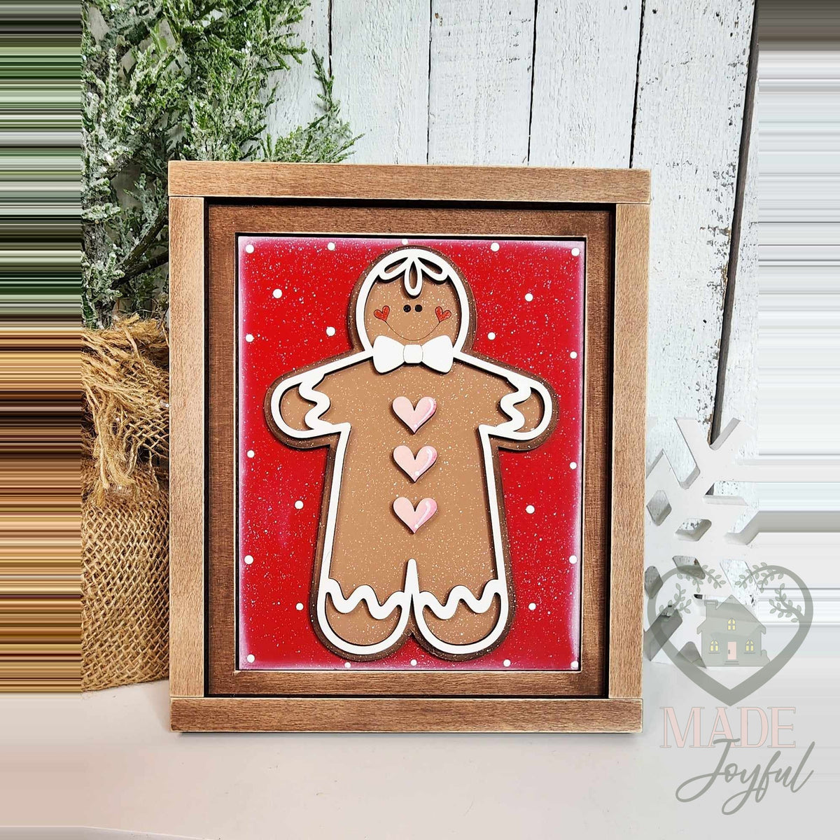 Hand-painted 3D wood gingerbread man with pink hearts and a white bow tie on a red polka-dot background in a stained 7x8 farmhouse frame.