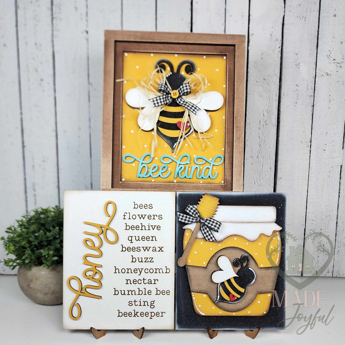 Honey Bee insert trio for interchangeable farmhouse frames: a Bee Kind bee in a stained wood frame with a Honey word-list sign and a honey jar insert on stands, hand-painted in Brentwood, TN.