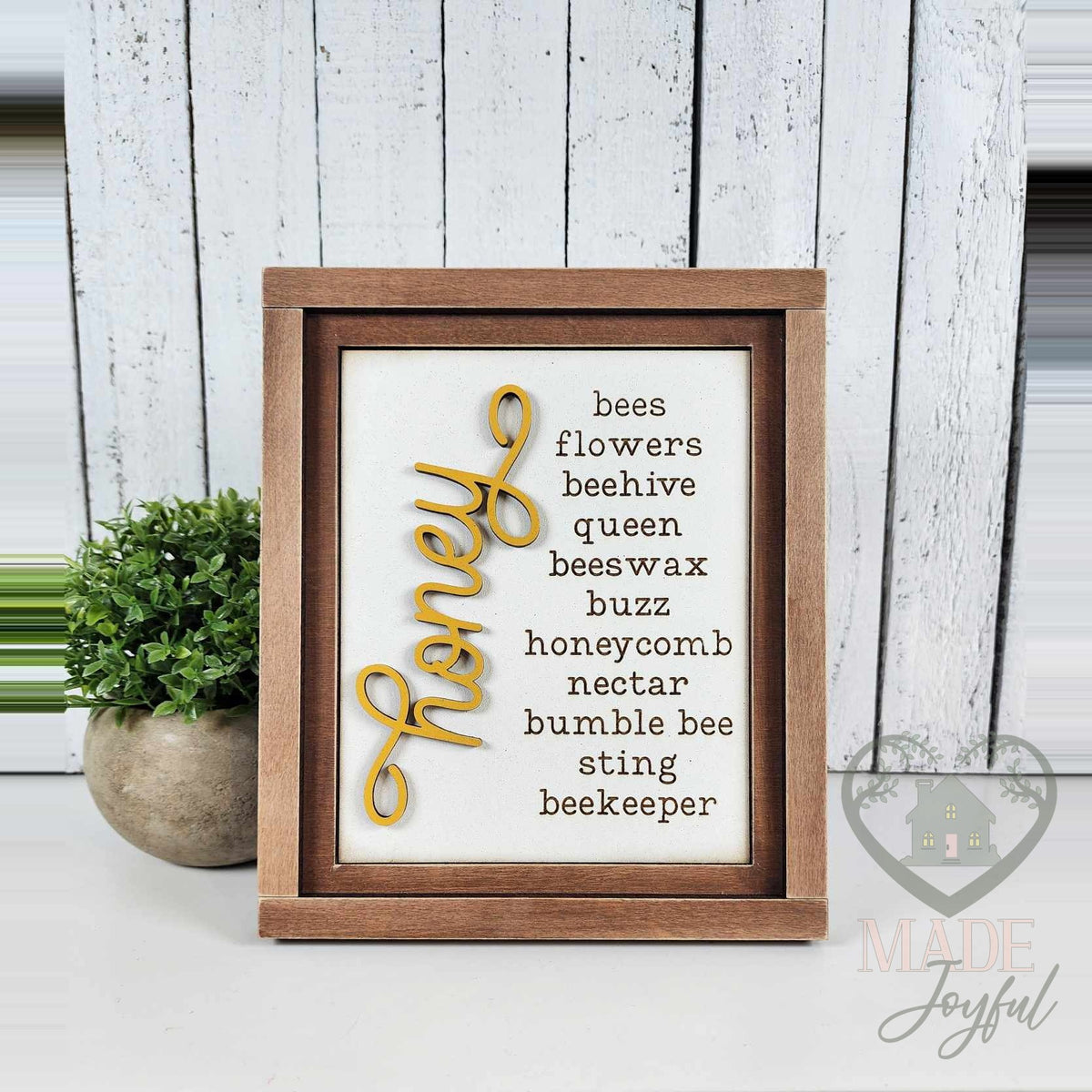 Honey word-list insert with bees, flowers, beehive, queen, beeswax, buzz, honeycomb, nectar, bumble bee, and beekeeper in a stained farmhouse frame.