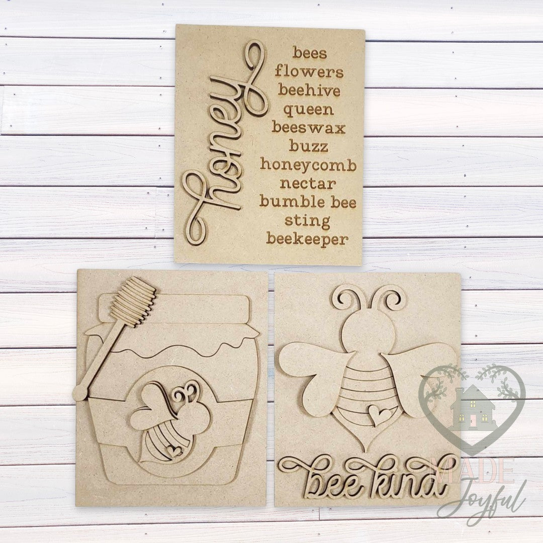 Unfinished laser-cut wood Honey Bee trio DIY kit with Honey word list, honey jar, and Bee Kind inserts, ready to paint at a DIY party in Williamson County, TN.