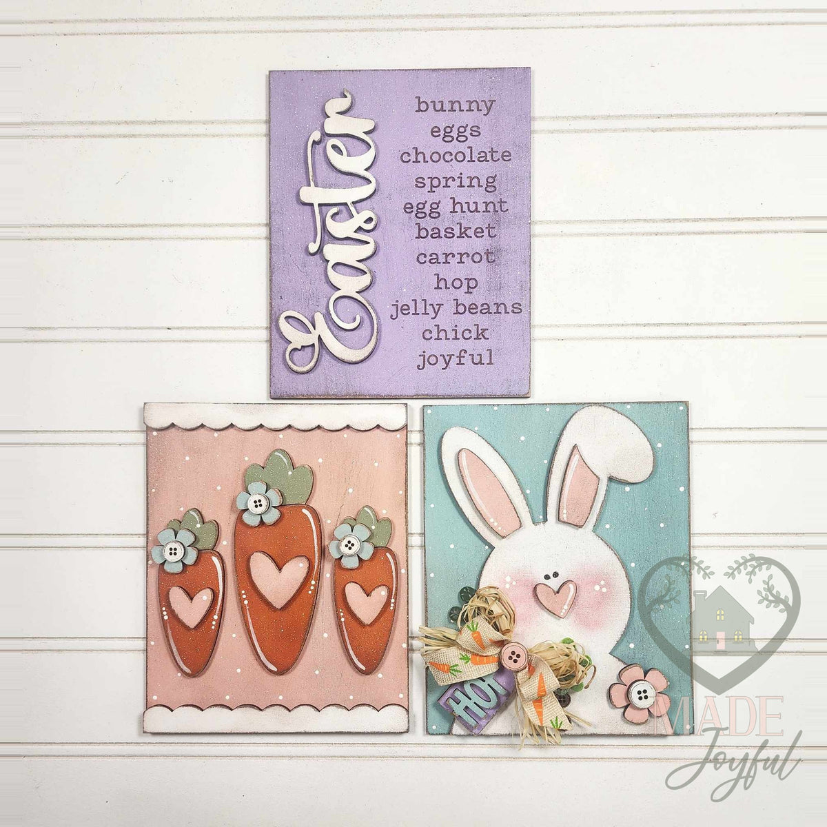 Prim Easter insert trio of hand-painted 3D wood signs: a lavender Easter word list, three heart carrots on pink, and a white bunny with a HOP tag on blue, made in Brentwood, TN.