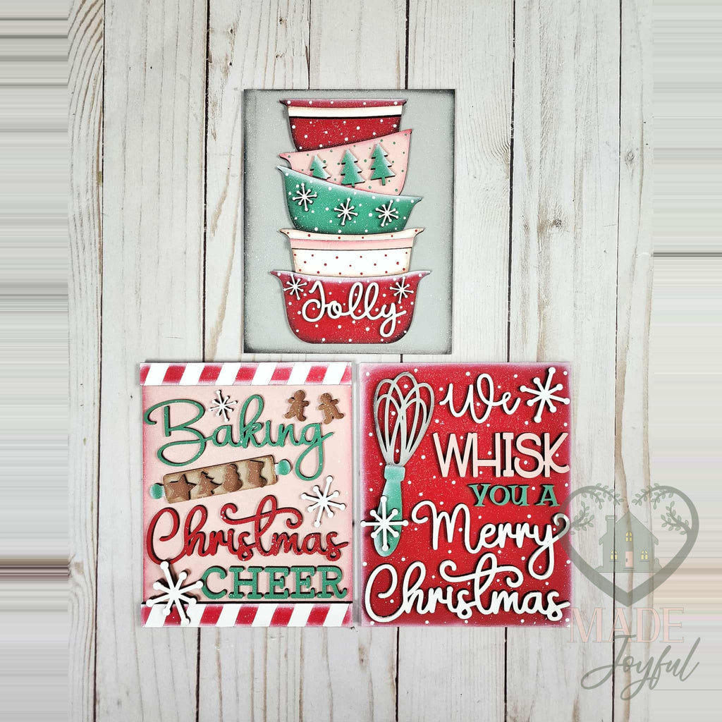 Christmas Baking insert trio of hand-painted 3D wood signs: stacked vintage Jolly mixing bowls, Baking Christmas Cheer with a rolling pin, and We Whisk You a Merry Christmas, made in Brentwood, TN.