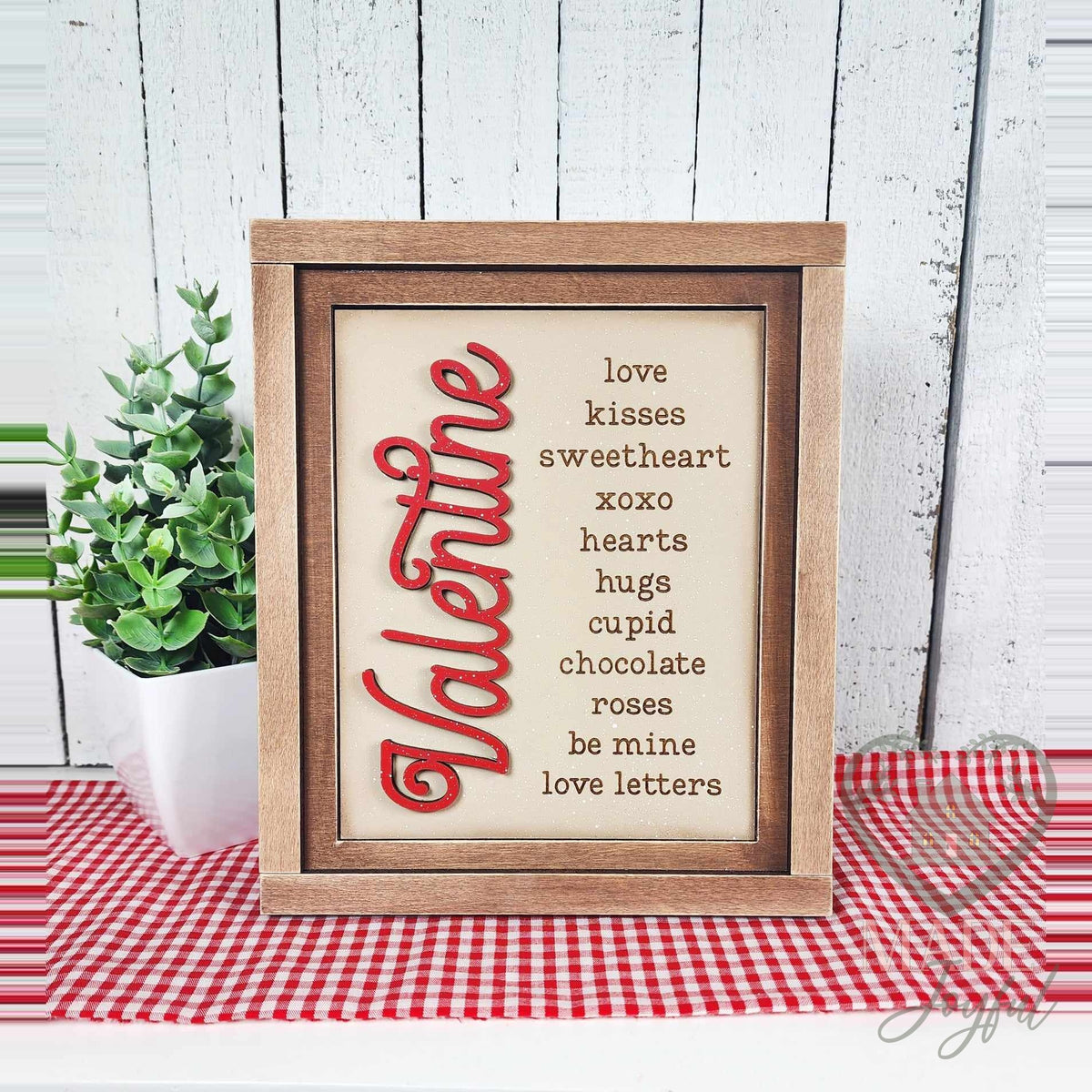 Valentine word-list insert with love, kisses, sweetheart, xoxo, hearts, hugs, cupid, chocolate, roses, be mine, and love letters in red script, in a stained farmhouse frame.