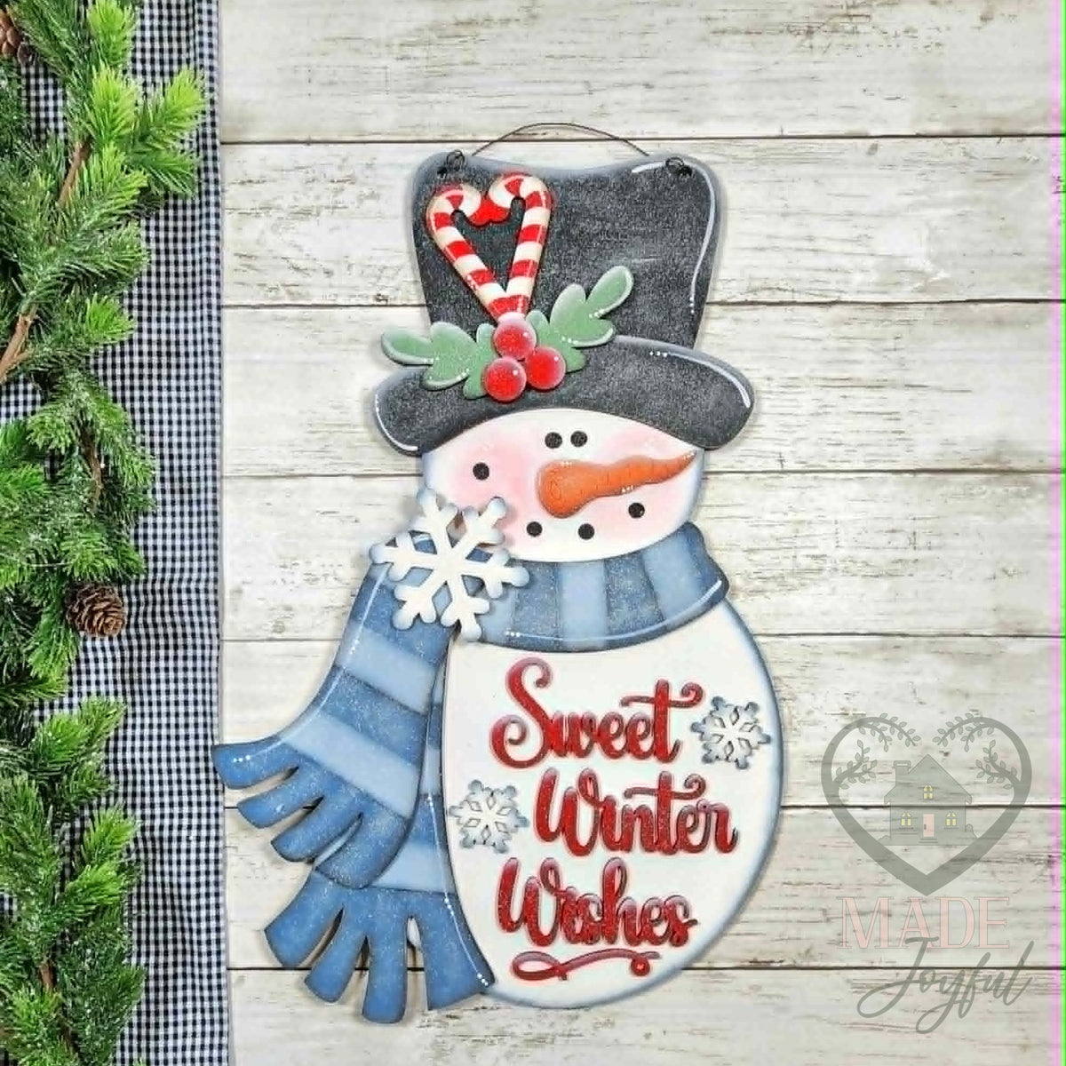 Sweet Winter Wishes snowman 3D wood door hanger with a black top hat, candy cane, blue scarf, and red script, hand-painted in Brentwood, TN.