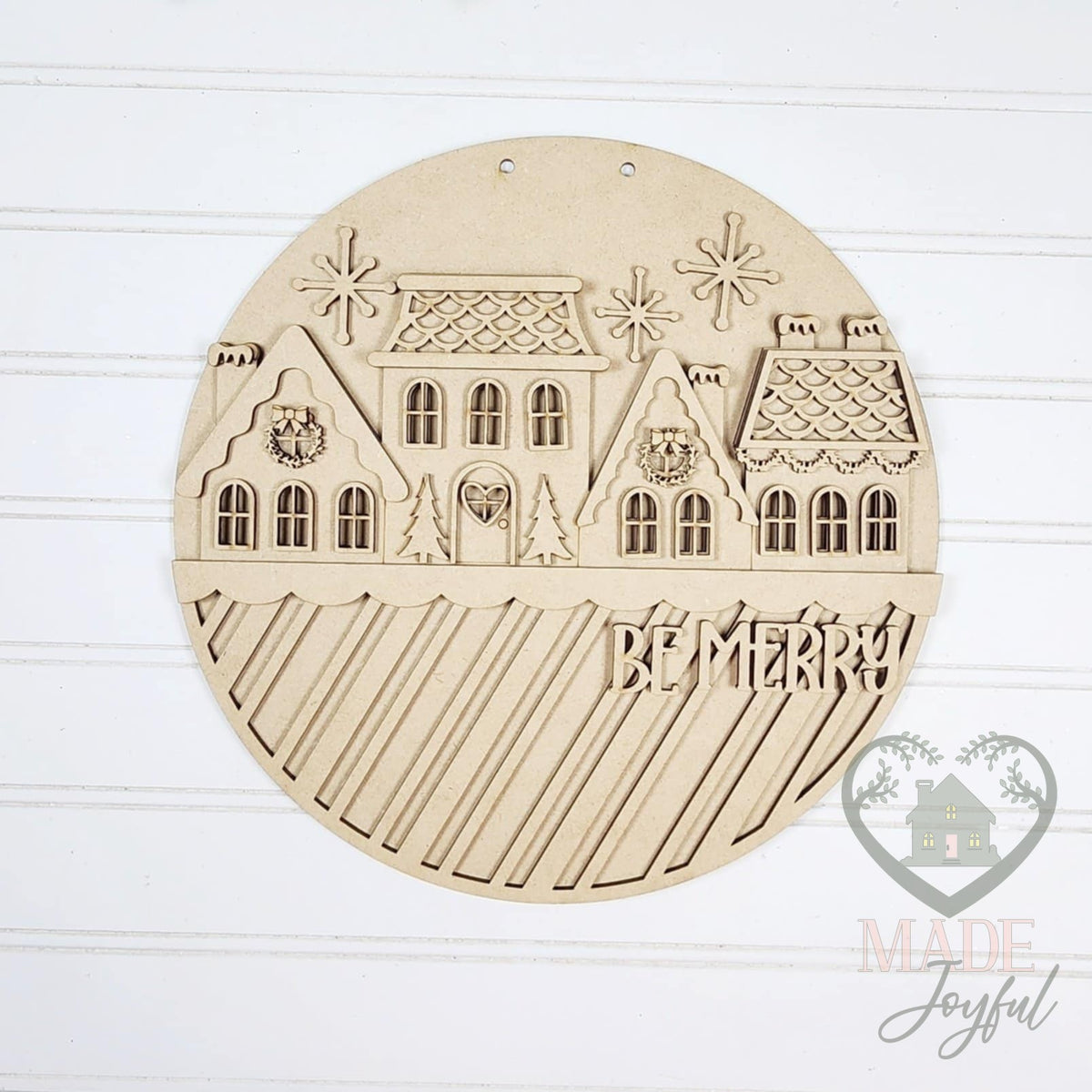 Unfinished laser-cut wood Gingerbread Village Be Merry door hanger kit, ready to paint at a DIY party in Williamson County, TN.