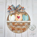 Harvest Blessings round wood door hanger with white, orange, and teal pumpkins, lattice band, and plaid bow, hand-painted in Brentwood, TN.