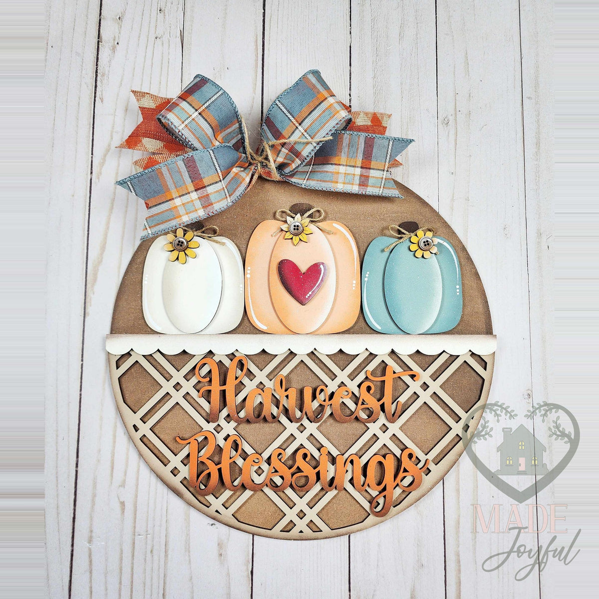 Harvest Blessings round wood door hanger with white, orange, and teal pumpkins, lattice band, and plaid bow, hand-painted in Brentwood, TN.