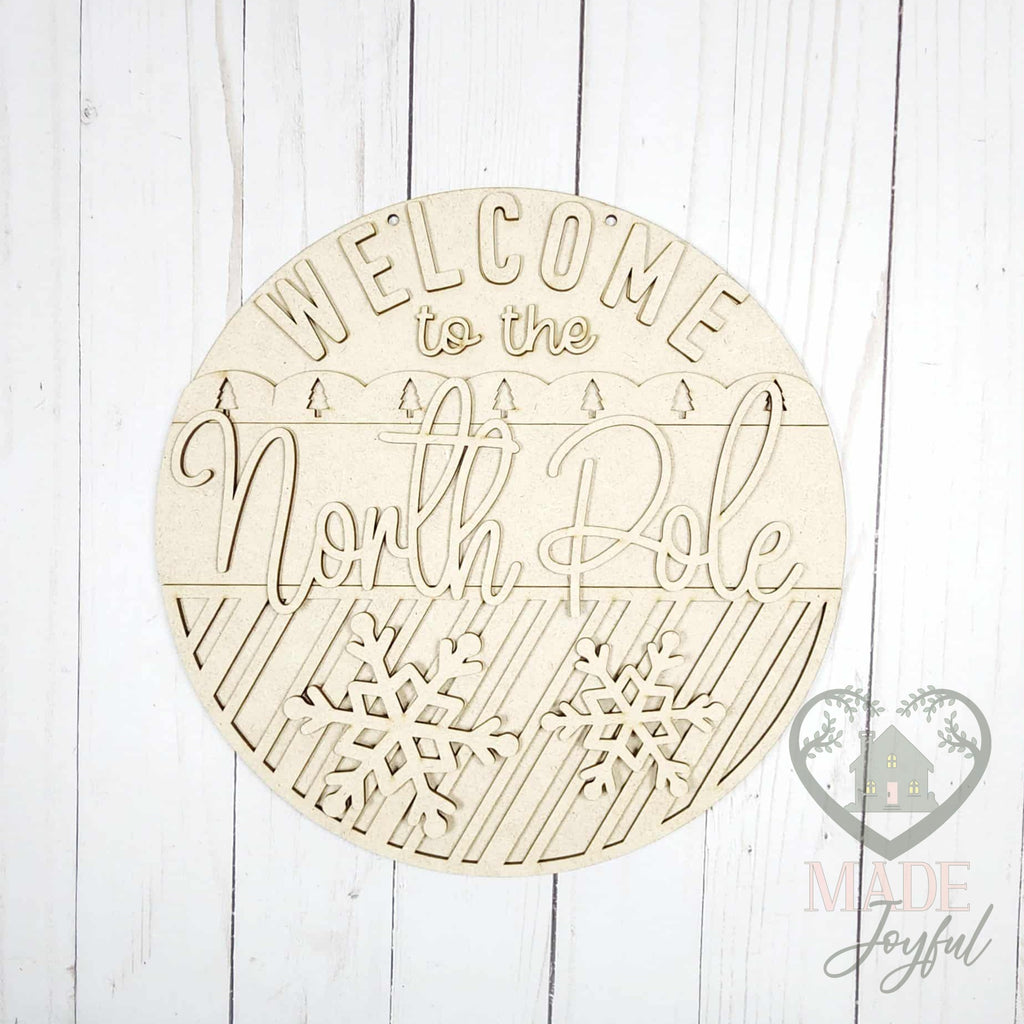 Unfinished laser-cut wood Welcome to the North Pole door hanger kit, ready to paint at a DIY party in Williamson County, TN.