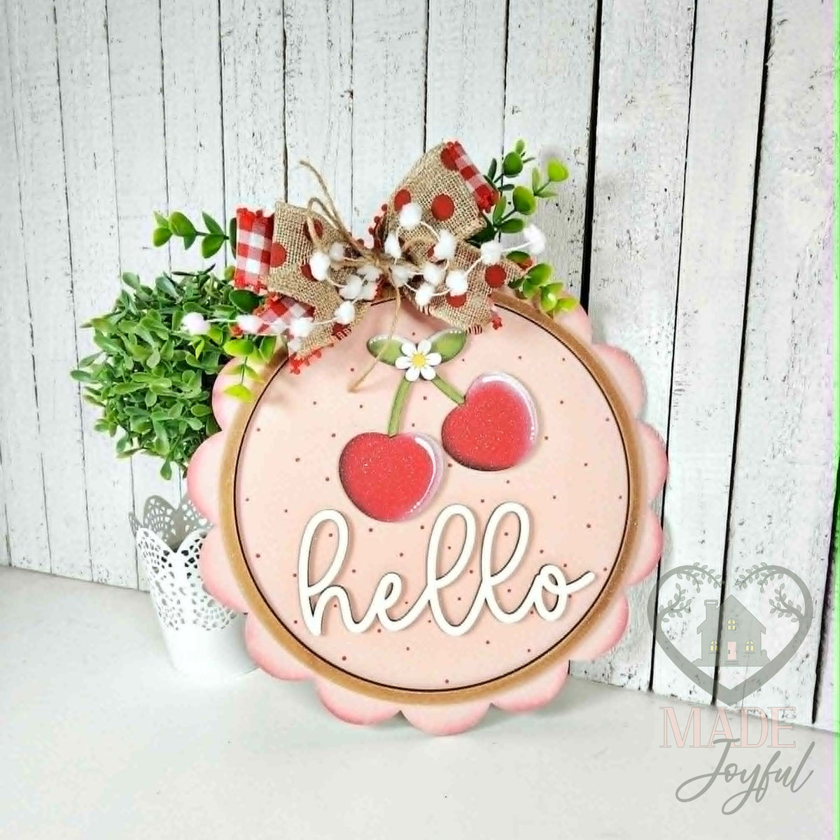 Hello Cherry scalloped wood door hanger with red cherries and white script on blush pink, topped with a gingham bow, hand-painted in Brentwood, TN.