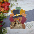 Give Thanks pilgrim turkey 3D wood door hanger with a buckled hat, plaid bow, and layered fall feathers, styled with autumn leaves, hand-painted in Brentwood, TN.