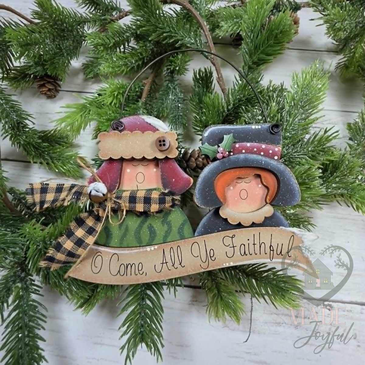 Christmas caroler ornament with two singers in a bonnet and top hat above an O Come All Ye Faithful banner, with plaid fabric, hand-painted in Brentwood, TN.