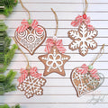 Five gingerbread cookie ornaments shaped like hearts, a star and snowflakes with white icing details and striped bows, hand-painted in Brentwood, TN.