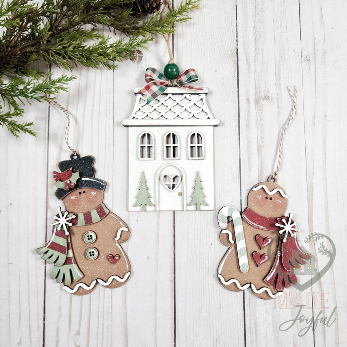 Victorian gingerbread ornament set with a white gingerbread house and two gingerbread men in scarves and a top hat, hand-painted in Brentwood, TN.