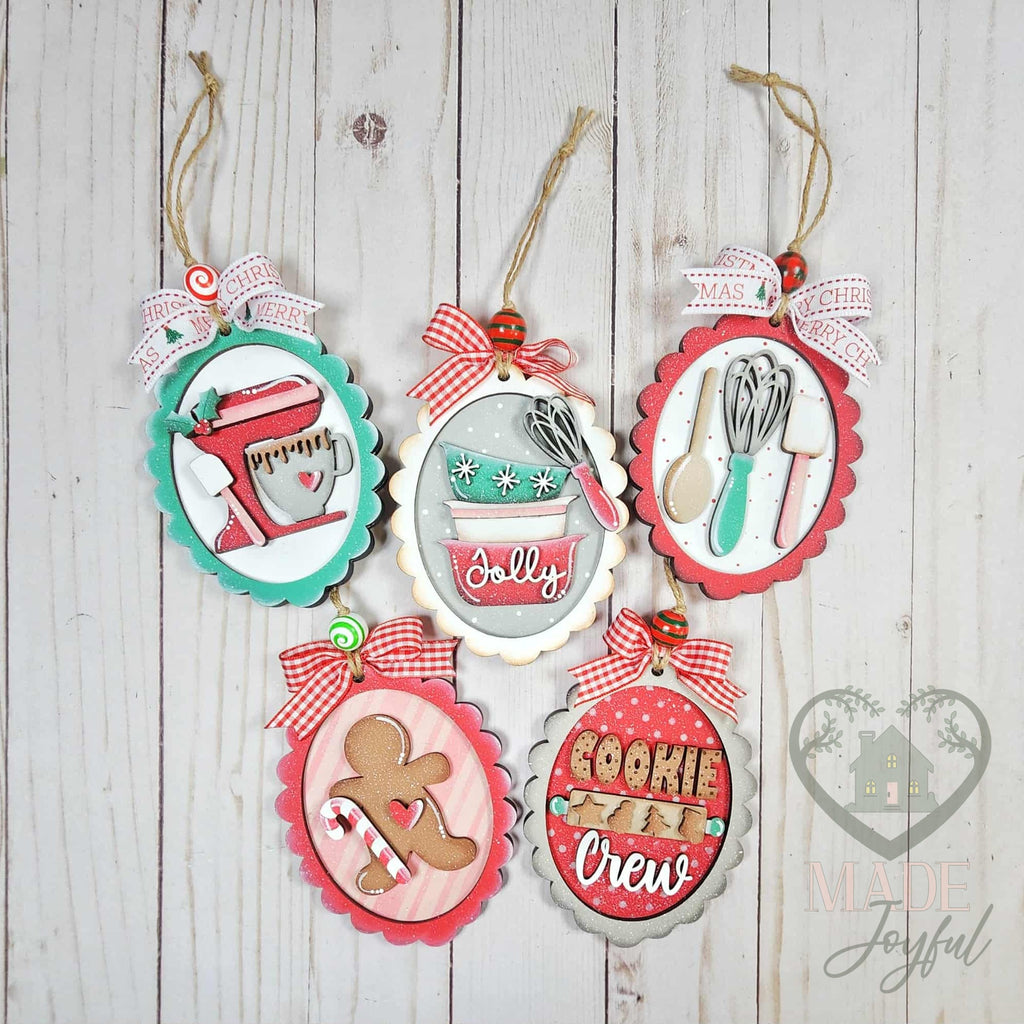 Five retro Christmas baking ornaments with a stand mixer, mixing bowls, utensils, gingerbread man and Cookie Crew in scalloped frames, hand-painted in Brentwood, TN.