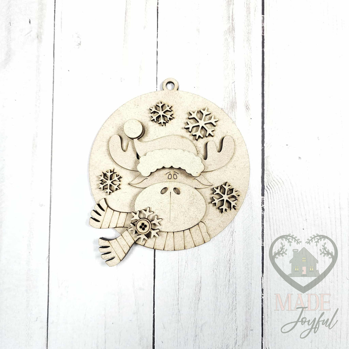 Unfinished laser-cut wood round moose ornament kit with snowflakes, ready to paint at a DIY party in Williamson County, TN.