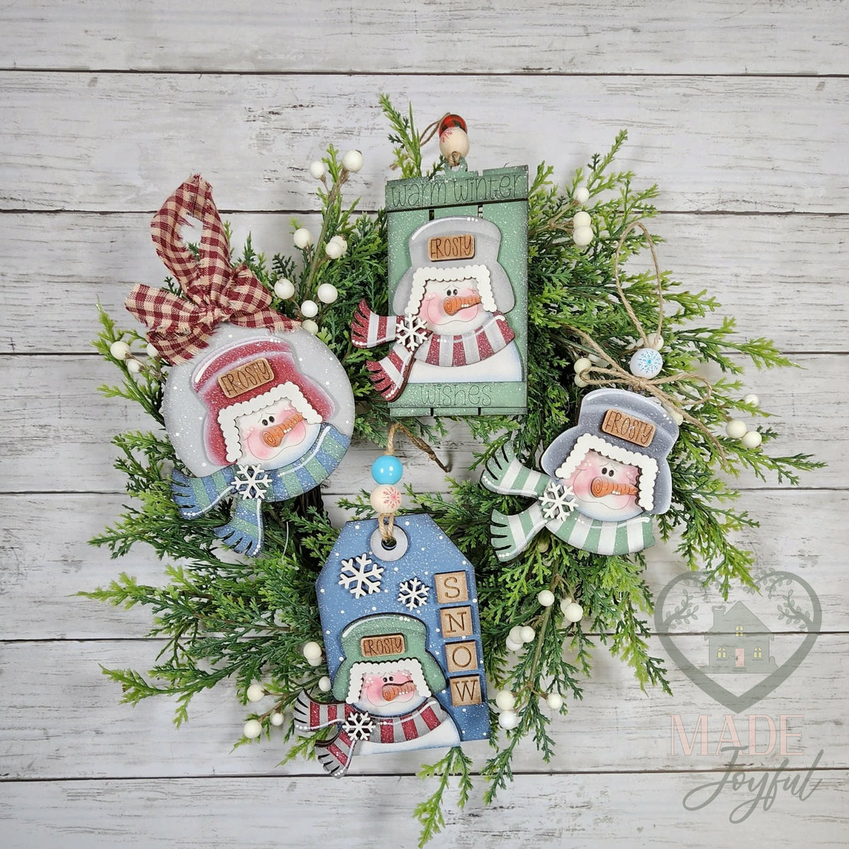 Winter snowmen ornament set with four snowmen in trapper hats, including a SNOW tag and gift card holder, on a wreath, hand-painted in Brentwood, TN.