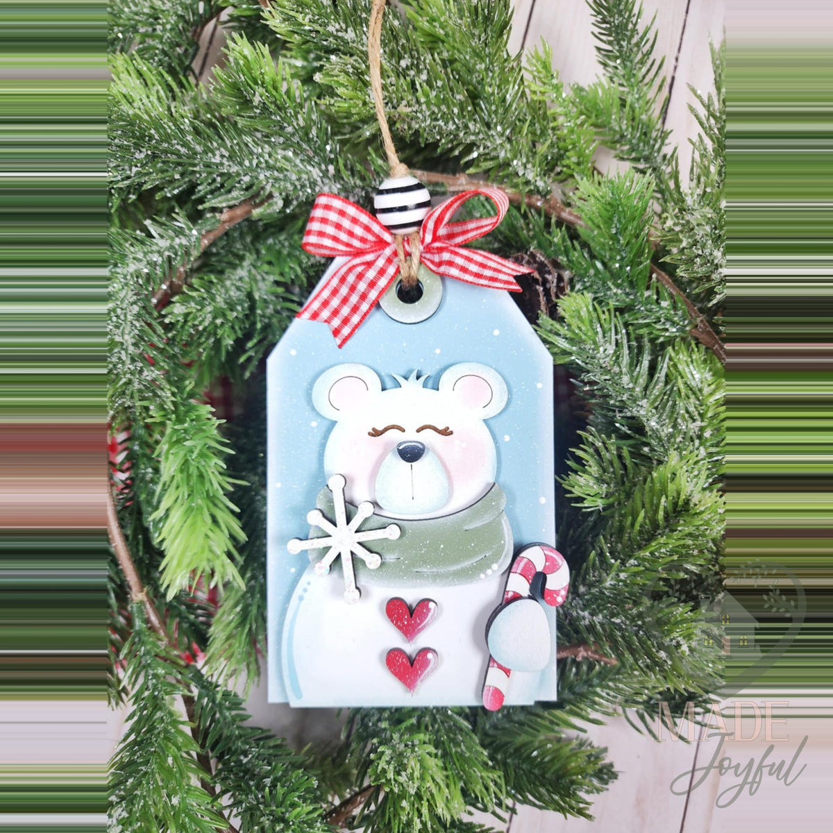 Polar bear tag ornament with a snowflake, hearts and candy cane, topped with a red gingham bow, hand-painted in Brentwood, TN.