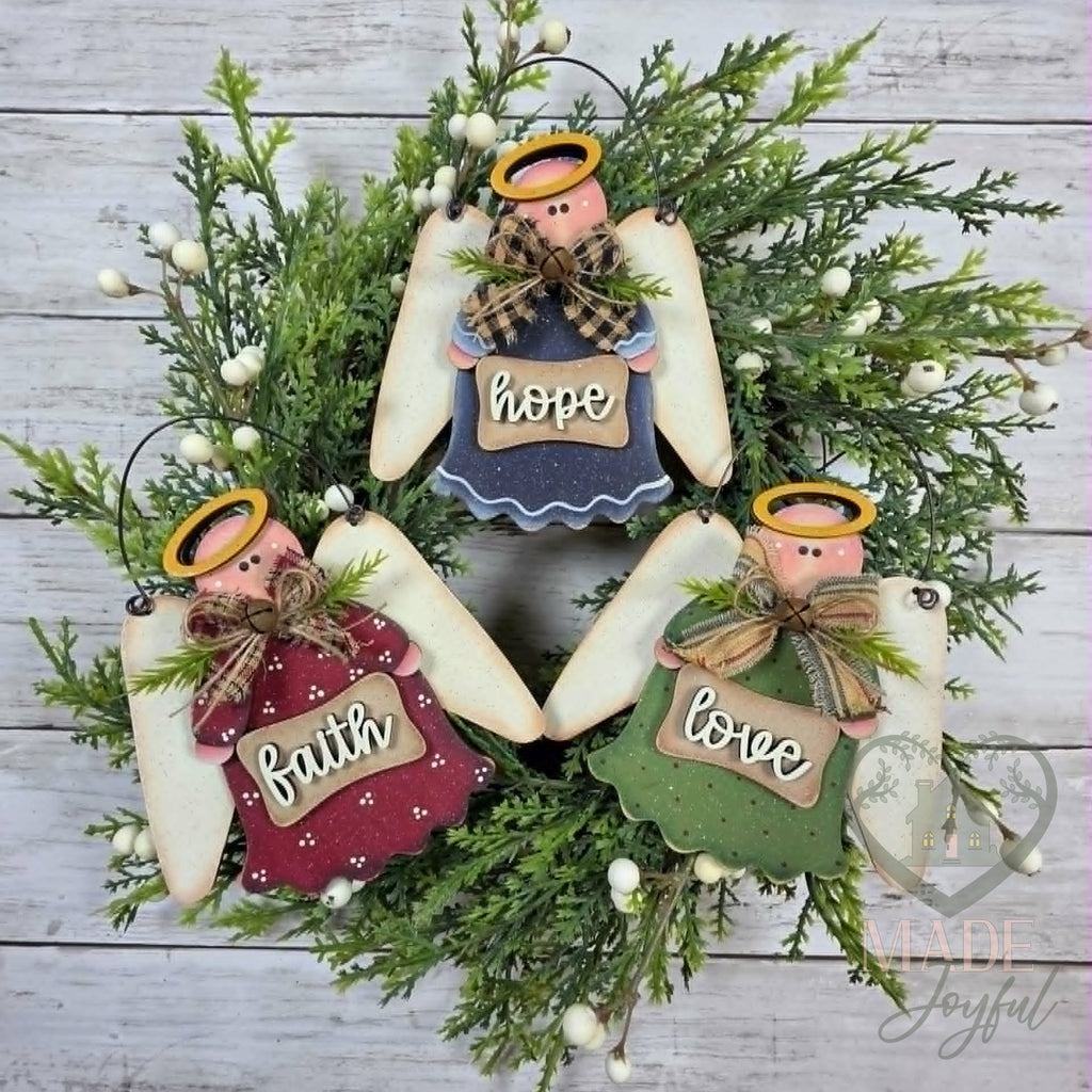 Three prim angel ornaments holding Faith, Hope and Love signs with homespun bows and halos, on a wreath, hand-painted in Brentwood, TN.