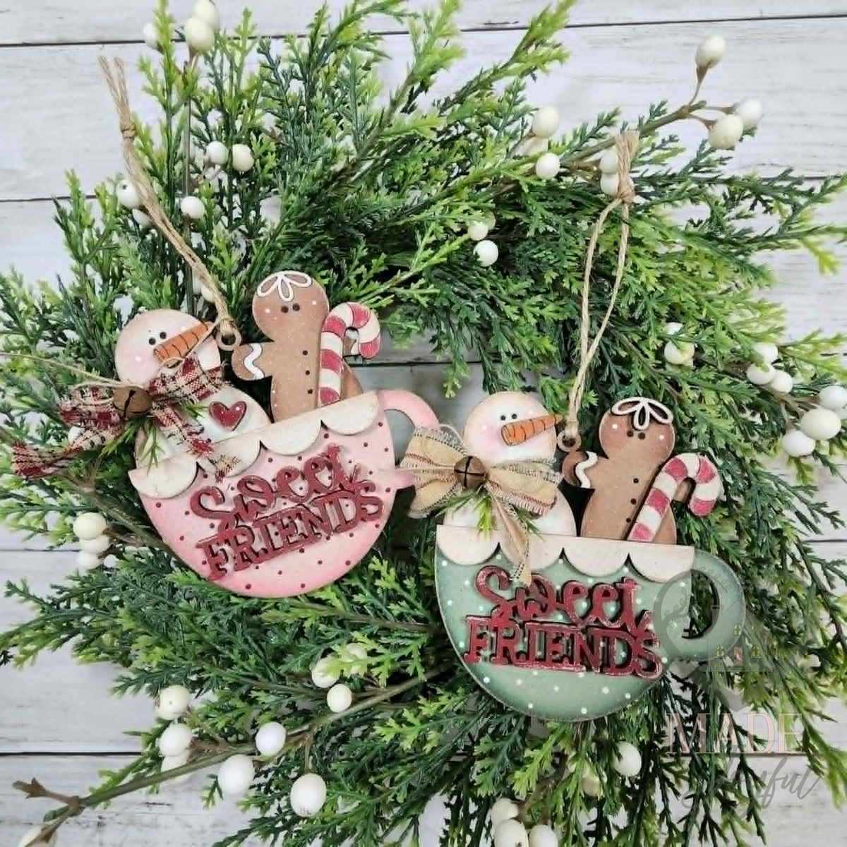 Two Sweet Friends ornaments with a snowman and gingerbread man in pink and green cocoa mugs with candy canes, hand-painted in Brentwood, TN.