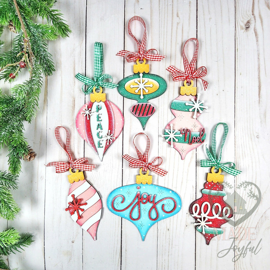 Six vintage-style wood ornaments in pink, aqua and red with Joy, Peace and Noel lettering and gingham ribbon, hand-painted in Brentwood, TN.