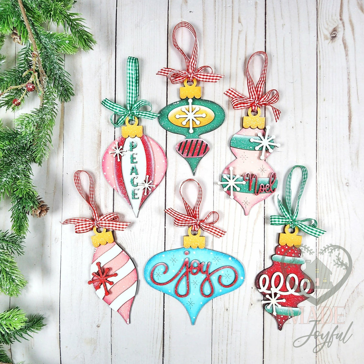 Six vintage-style wood ornaments in pink, aqua and red with Joy, Peace and Noel lettering and gingham ribbon, hand-painted in Brentwood, TN.