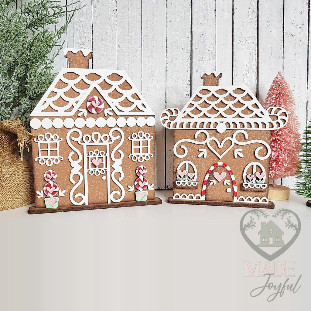 Pair of frosted gingerbread house shelf sitters with white icing roofs and candy trim, hand-painted in Brentwood, TN.
