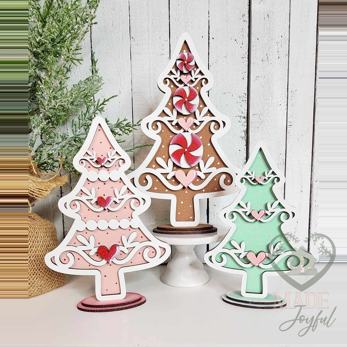 Three gingerbread Christmas tree shelf sitters in pink, brown, and mint with peppermints, hand-painted in Brentwood, TN.