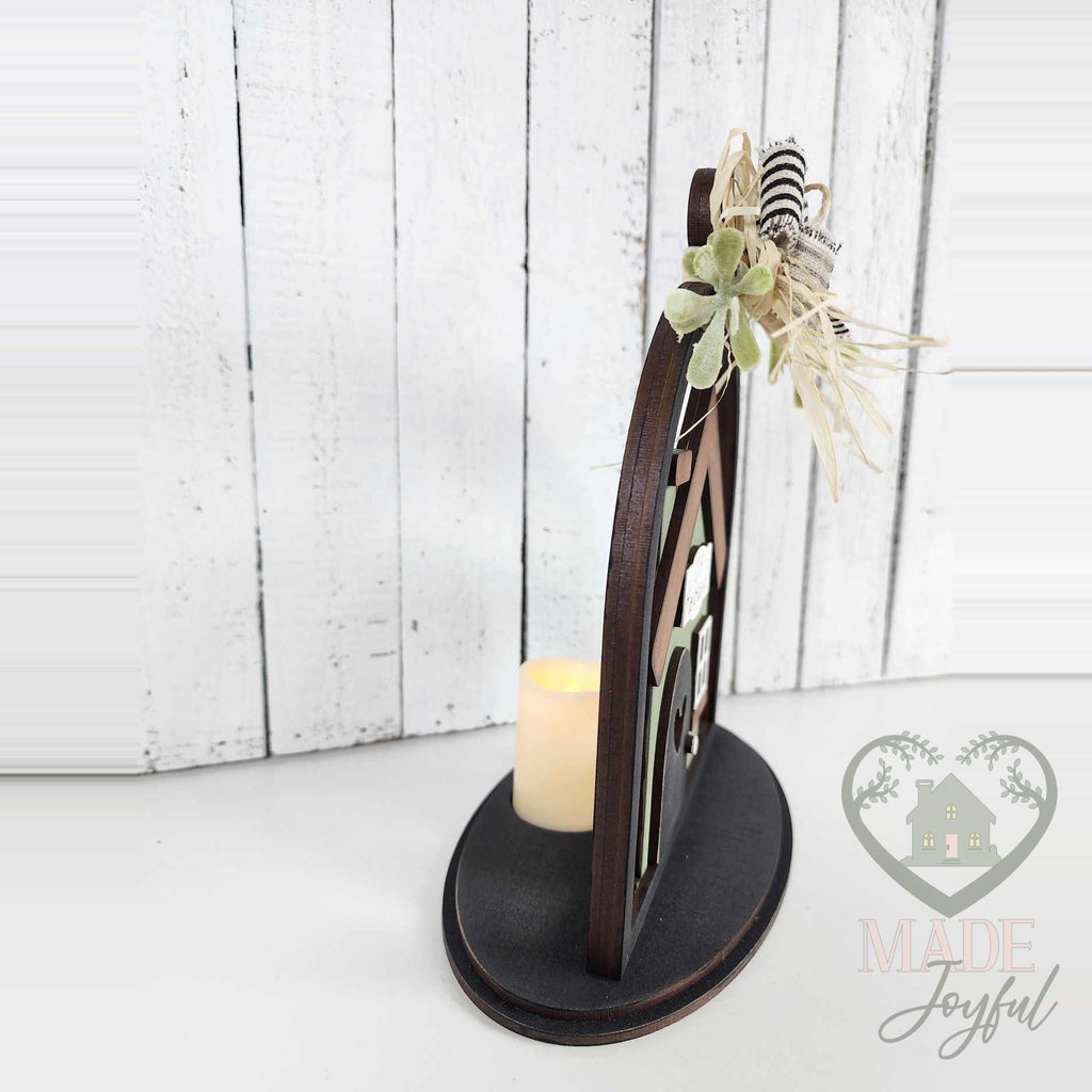 Side view of the home cloche with a glowing LED tealight, hand-painted in Brentwood, TN.
