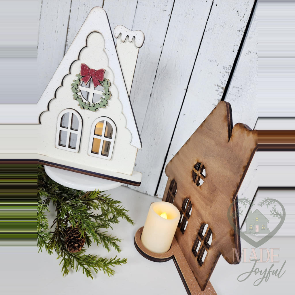 Gingerbread house votive glowing from an LED tealight, hand-painted in Brentwood, TN.