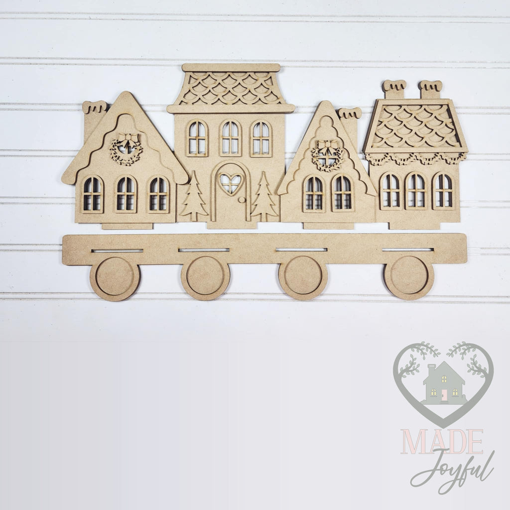 Unfinished laser-cut wood Gingerbread Village Light Up Shelf Sitter DIY kit, ready to paint at a DIY party in Williamson County, TN.