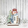 Winter snowman shelf sitter with trapper hat, blue scarf, lit tree, and SNOW blocks, hand-painted in Brentwood, TN.