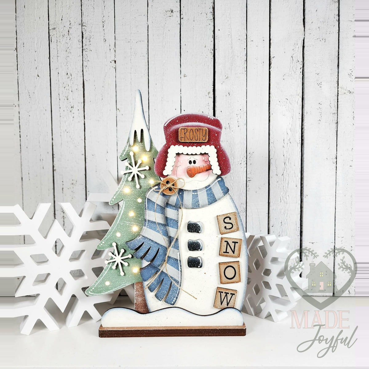 Winter snowman shelf sitter with trapper hat, blue scarf, lit tree, and SNOW blocks, hand-painted in Brentwood, TN.