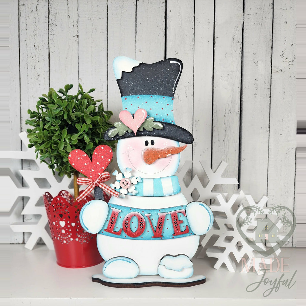 Love snowman shelf sitter in teal top hat holding LOVE sign, hand-painted in Brentwood, TN.