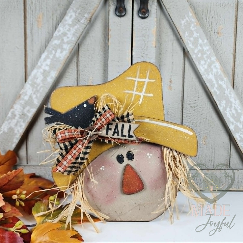 Scarecrow face shelf sitter with straw hat, crow, and plaid bow, hand-painted in Brentwood, TN.