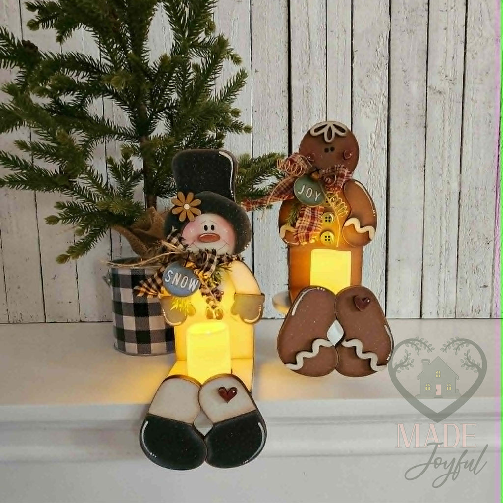 Snowman and gingerbread votive shelf sitters glowing, hand-painted in Brentwood, TN.