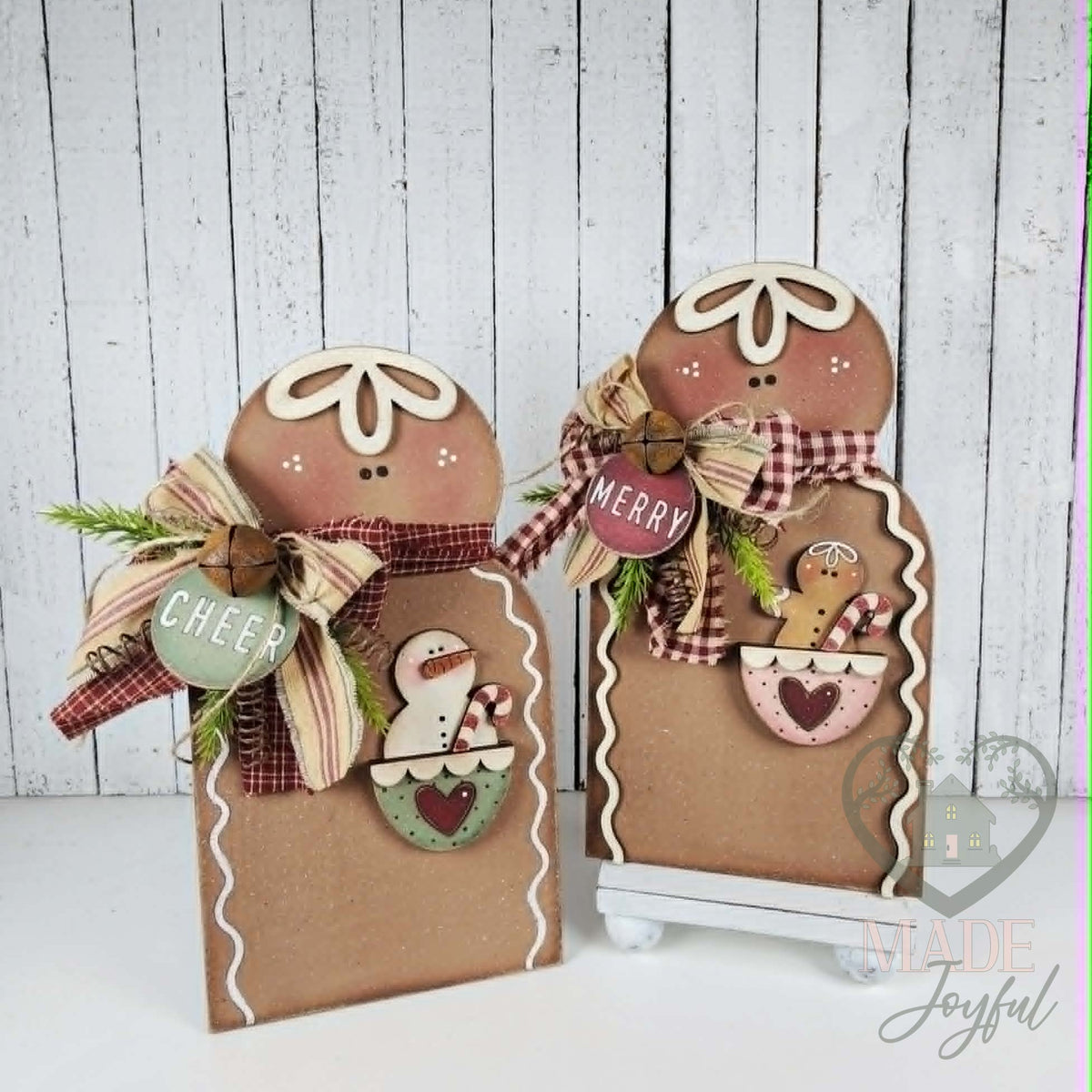 Pair of pocket gingerbread shelf sitters with Cheer and Merry tags, hand-painted in Brentwood, TN.