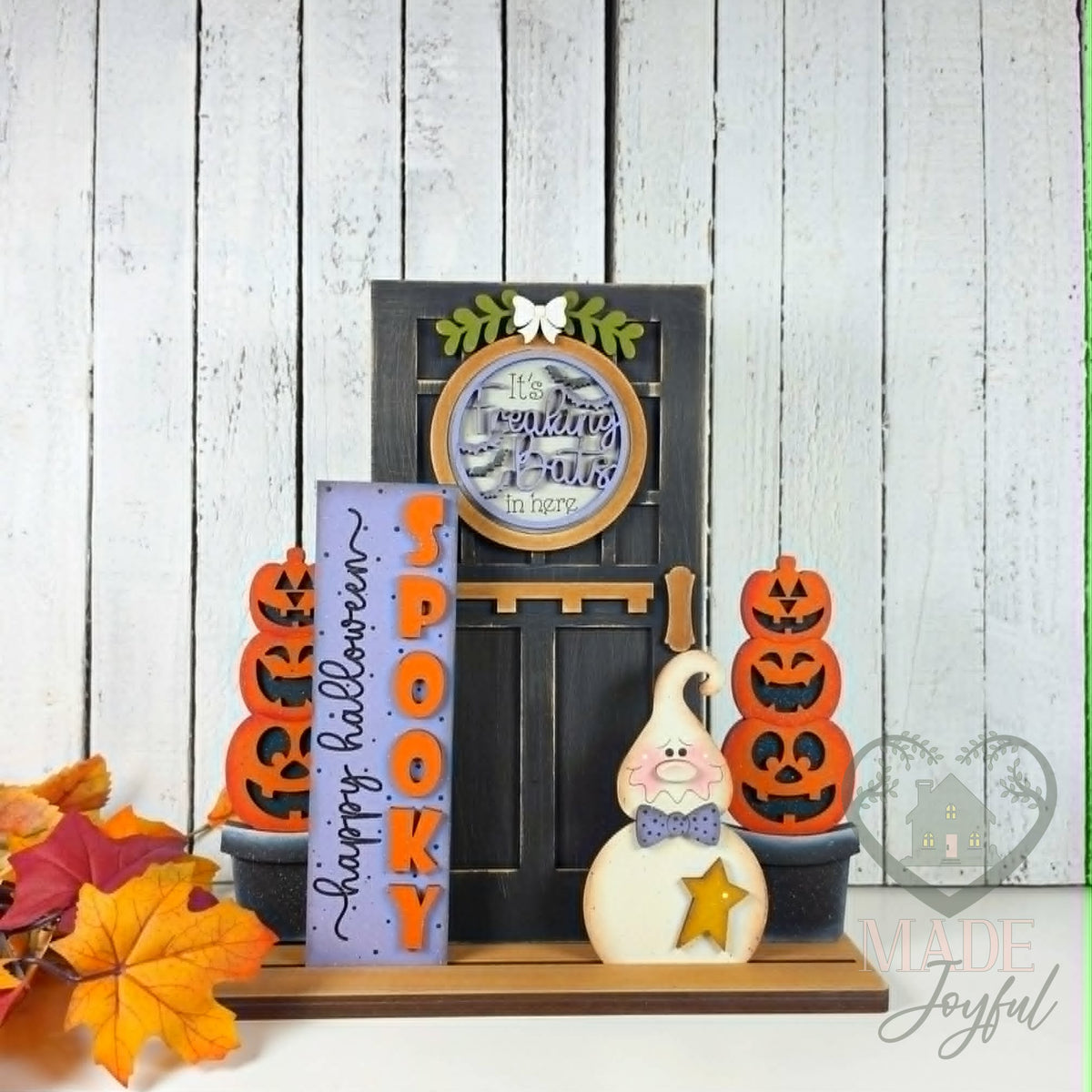 Spooky Halloween porch set with black door and pumpkin topiaries, hand-painted in Brentwood, TN.