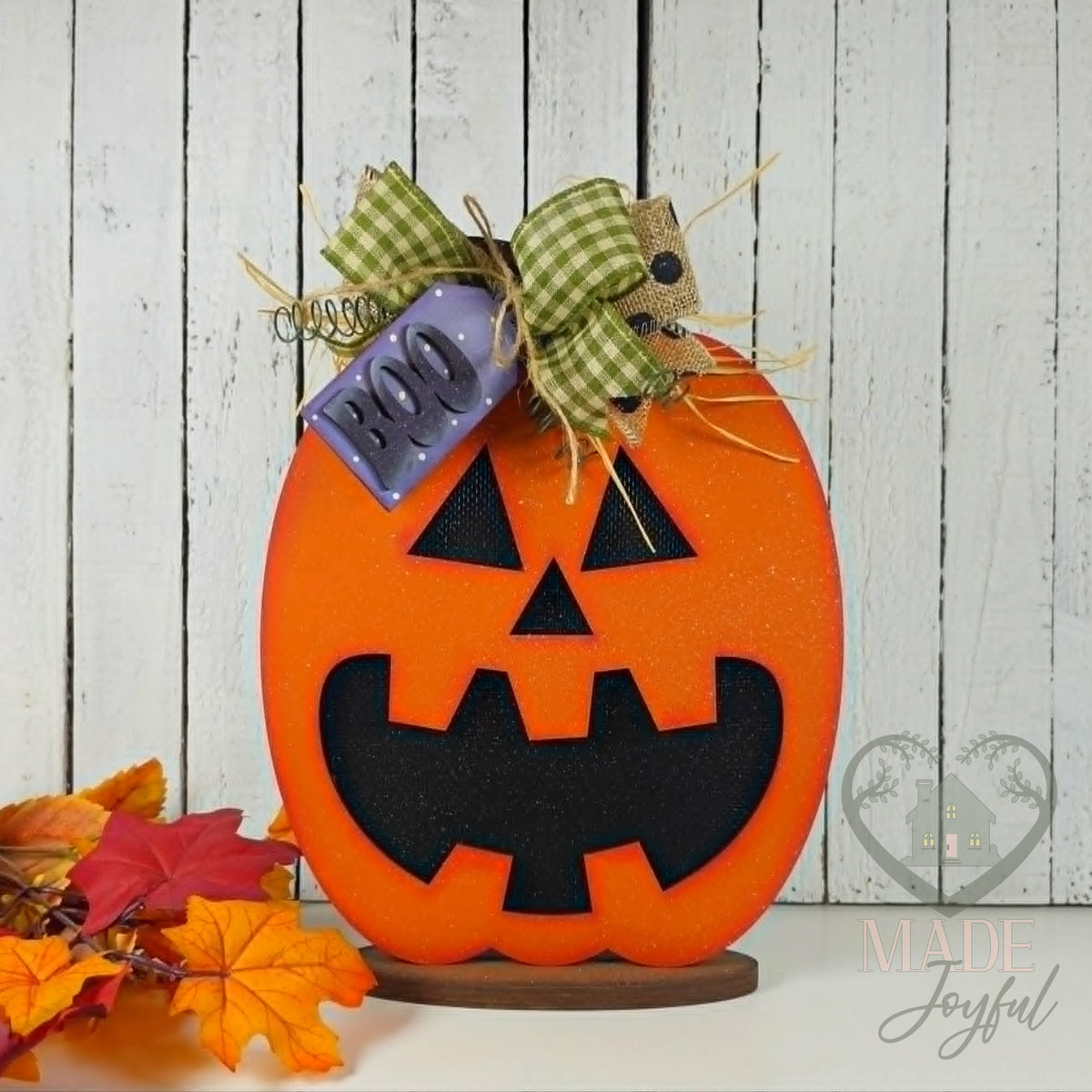 Jack-o-lantern shelf sitter with BOO tag and plaid bow, hand-painted in Brentwood, TN.