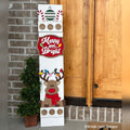 Merry and Bright interchangeable porch leaner with a reindeer wearing Christmas lights and a red scarf on a white wood base by a front door