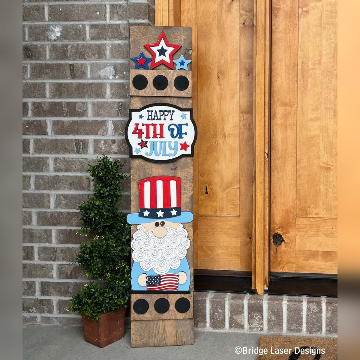 Happy 4th of July interchangeable porch leaner with stars, a Happy 4th of July sign, and an Uncle Sam gnome with a flag on a stained wood base