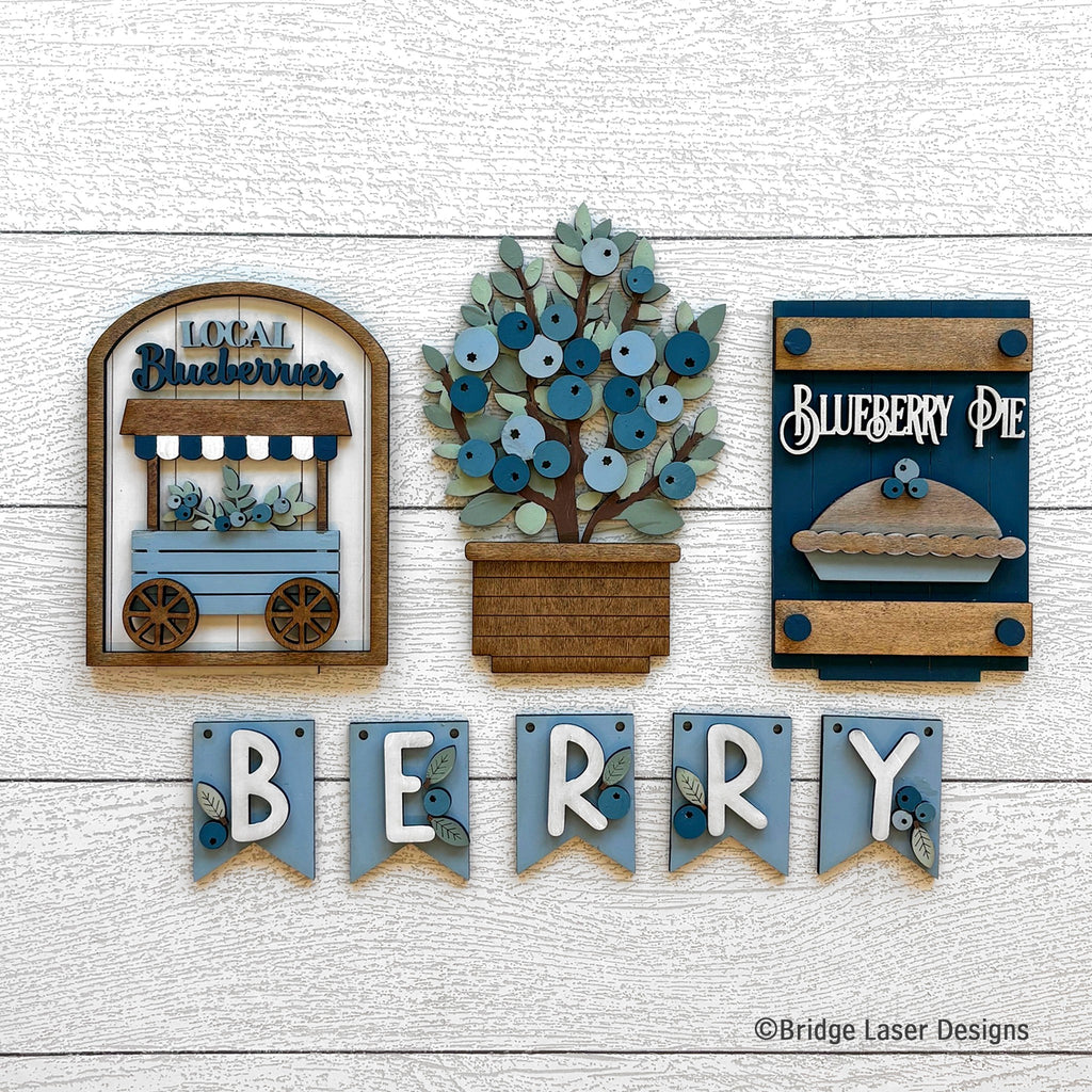 Blueberry interchangeable bench decor set with a Local Blueberries cart, a blueberry bush, a Blueberry Pie sign, and a BERRY banner