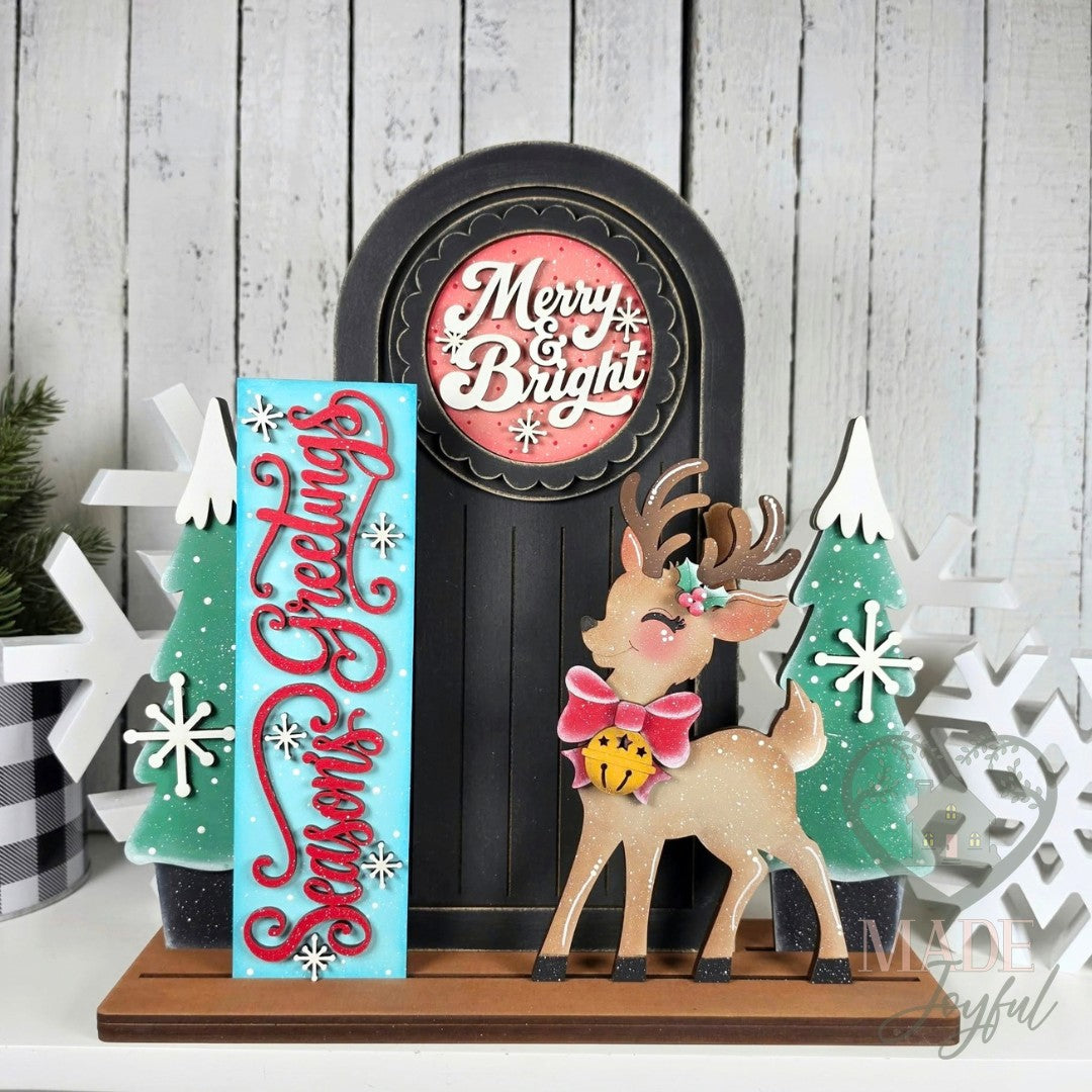 Retro Christmas porch door insert set with Merry & Bright round, Season's Greetings sign, snowy trees, and reindeer on a black mini porch door, hand-painted in Brentwood, TN.