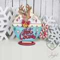 Reindeer peeking out of a blue Hot Cocoa cup shelf sitter with whipped cream, bow tie, and candy cane handle, hand-painted in Brentwood, TN.
