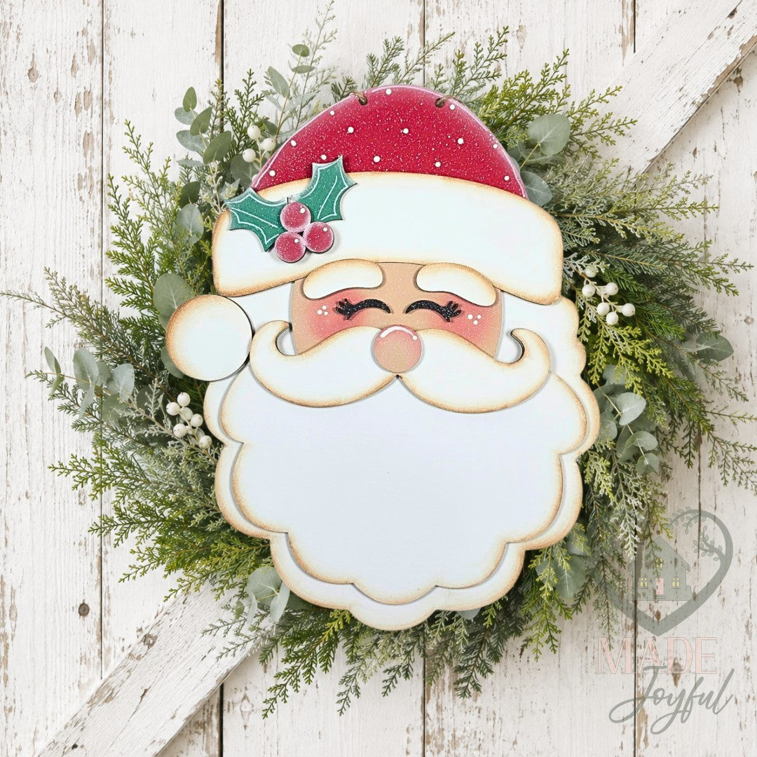 Retro Santa face door hanger with red hat and holly on a green wreath, hand-painted in Brentwood, TN.