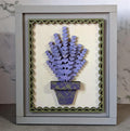 A framed layered wood frame insert  featuring a purple lavender bouquet in a patterned pot, set against an off-white background with a decorative olive green scalloped border, housed in a light gray frame. Painted in Bretnwood, TN available for diy parties in williamson county, tn